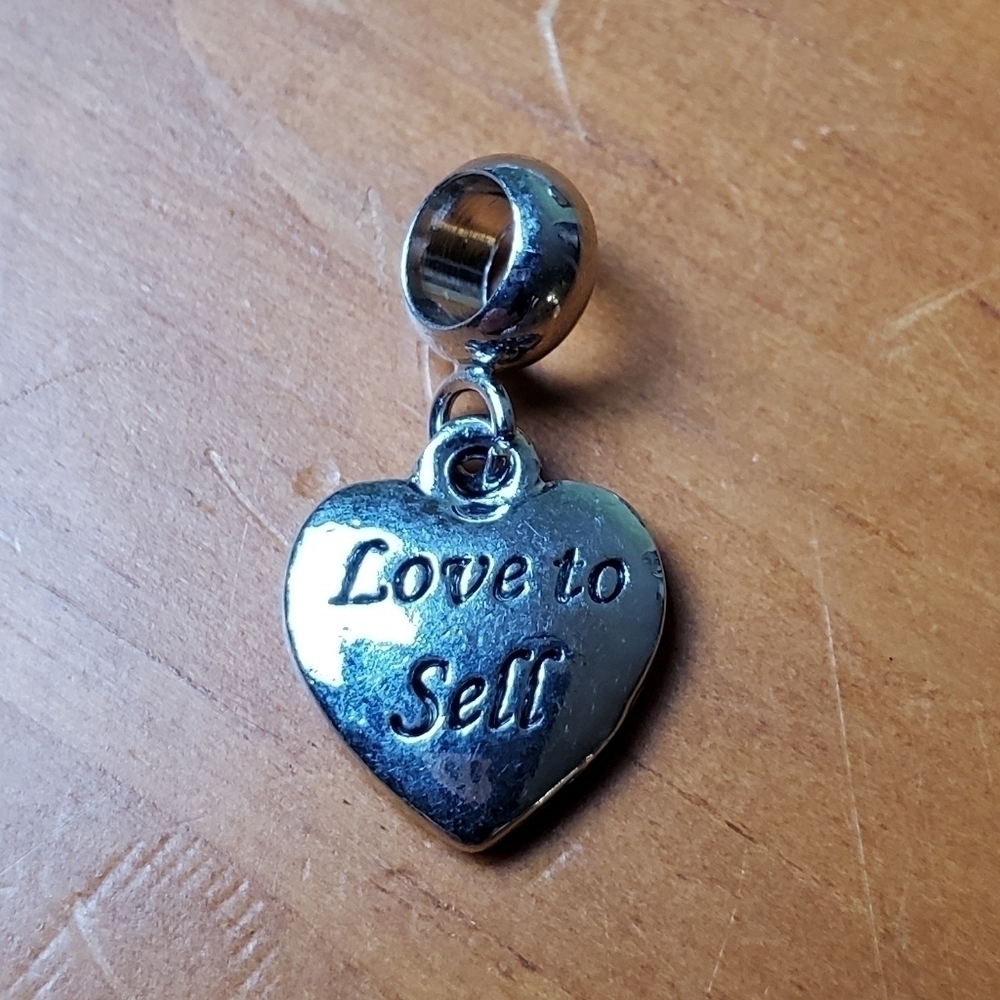 NWOT charm, silver colored heart, 'Love to Sell'